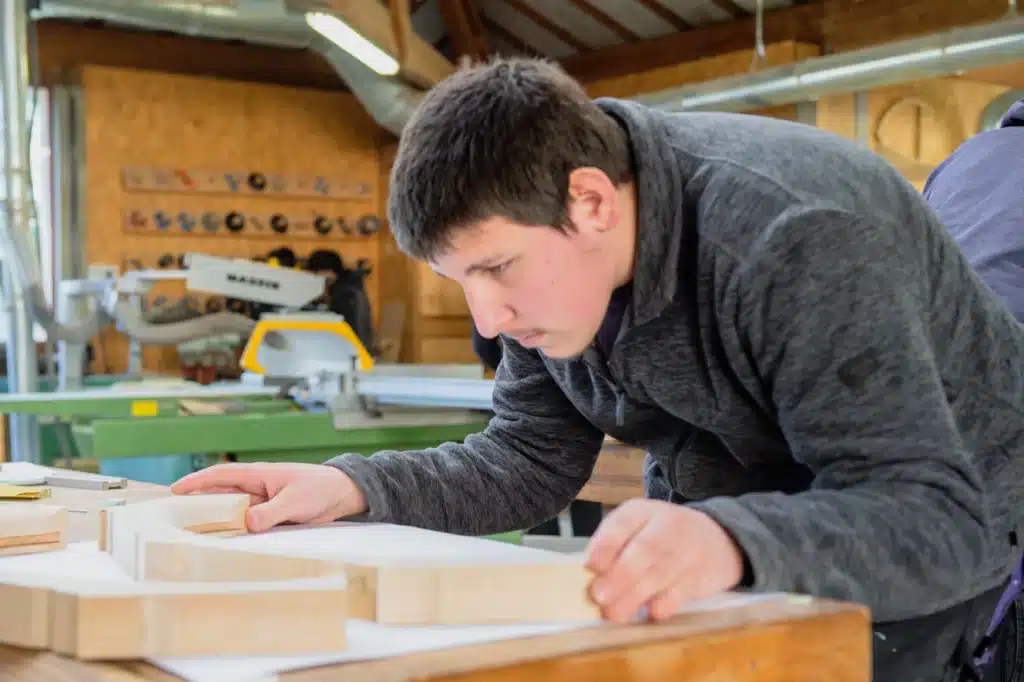 apprenti menuisier travaillant le bois dans un atelier mfr r
