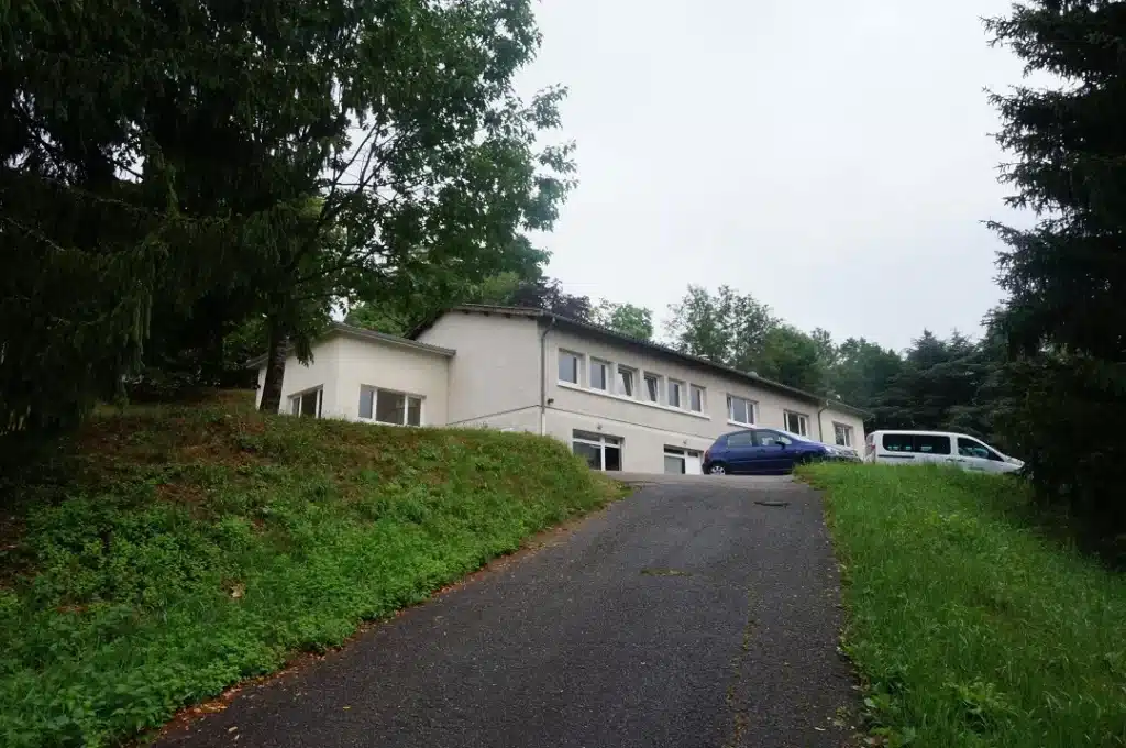 batiment mfr rhone avec voitures garees sur le chemin d acce