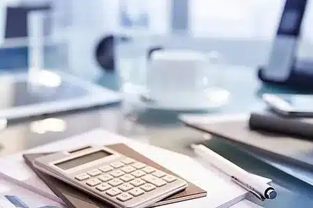 calculatrice et stylo sur un bureau mfr rhone