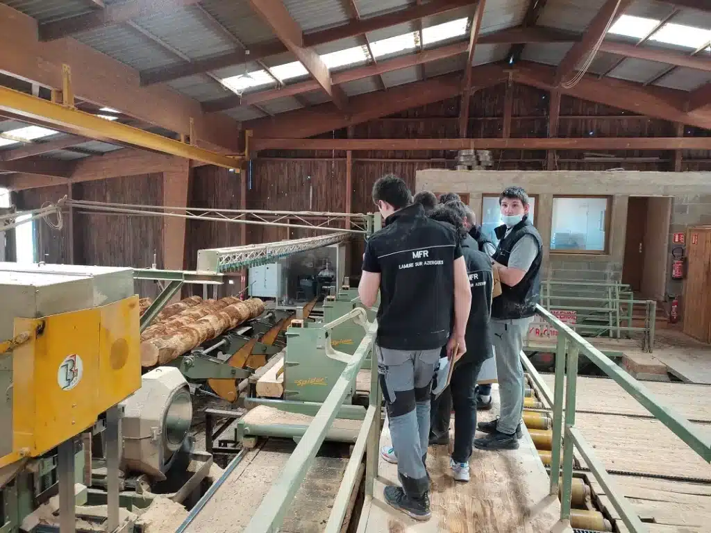 groupe d eleves mfr observant une scierie mobile avec troncs