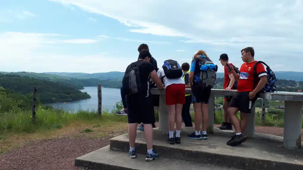 groupe de jeunes avec sacs a dos admirant un paysage de lac
