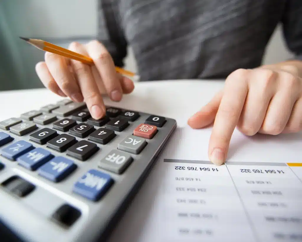 mains utilisant une calculatrice et un document chiffre mfr