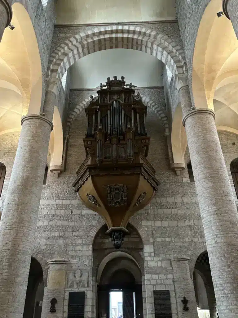 orgue ancien en bois sculpte suspendu a un mur de pierre dan