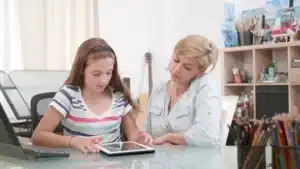 une jeune fille et une femme regardent une tablette avec des